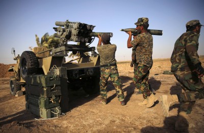 Shi'ite fighters from Mahdi Army load rockets into a rocket launcher during heavy fighting with Islamic State militants at Bo Hassan village in near Tikrit, northern Iraq September 12, 2014. REUTERS/Ahmed Jadallah (IRAQ - Tags: CIVIL UNREST CONFLICT)