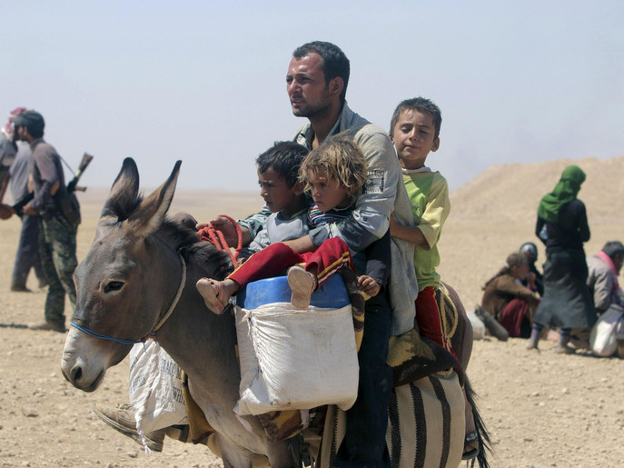 Displaced people from the minority Yazidi sect, fleeing violence from forces loyal to the Islamic State in Sinjar town, ride a donkey as they make their way towards the Syrian border, on the outskirts of Sinjar mountain, near the Syrian border town of Elierbeh of Al-Hasakah Governorate August 10, 2014. Islamic State militants have killed at least 500 members of Iraq's Yazidi ethnic minority during their offensive in the north, Iraq's human rights minister told Reuters on Sunday. The Islamic State, which has declared a caliphate in parts of Iraq and Syria, has prompted tens of thousands of Yazidis and Christians to flee for their lives during their push to within a 30-minute drive of the Kurdish regional capital Arbil.  Picture taken August 10, 2014. REUTERS/Rodi Said (IRAQ - Tags: POLITICS CIVIL UNREST CONFLICT ANIMALS)